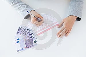 Close up of hands with lottery ticket and money