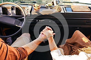 Close-up hands of lovely couple holding together, travelling on old retro van