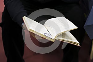 Close-up of hands of man in dark clothes with open book. Real scene in the store. Self-study, education, manuals