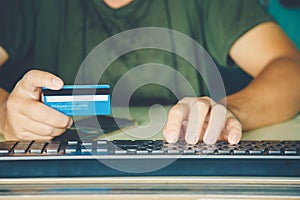 Close up a hands man holding credit card and use keyboard computer