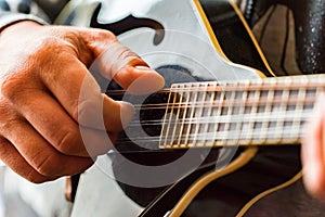 Close up hands of man playing 8-string mandolin