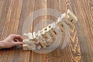 Close-up hands of man pulls out wooden bricks