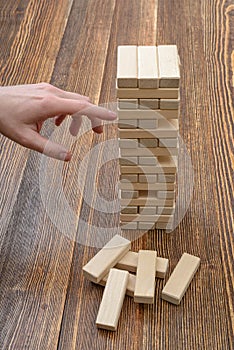 Close-up hands of man pulls out wooden bricks