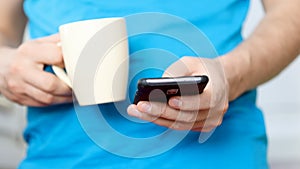 Close-up hands of man texting message on mobile phone.