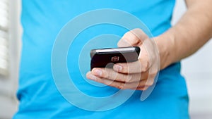 Close-up hands of man texting message on mobile phone.