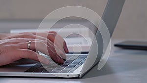 Close up of the hands of a man typing on a laptop