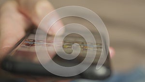 Close up of hands man using his smartphone to communicate online and watch content. Men's hands with a smartphone in