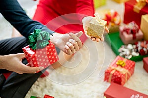 Close up hands of man and woman hold present or gift box for Christmas or new year celebration