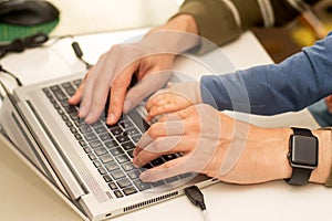 Close up of hands of a man working from home with the baby on his laps