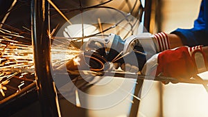 Close Up of Hands of a Metal Fabricator Wearing Safety Gloves and Grinding a Steel Tube Sculpture