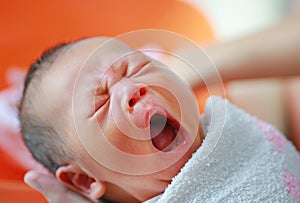 Close up hands of mother taking a bath to her newborn baby in a bathtub