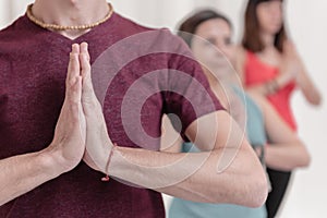 Close up of on the hands in Namaste`s gesture. The man in the foreground with the hands in Namaste`s gesture.