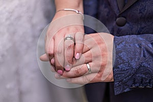 Close up of hands of a newly wed married couple with wedding rings.