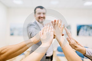 Close-up hands of office staff showing unity on a blurred background. Start-up project concept.