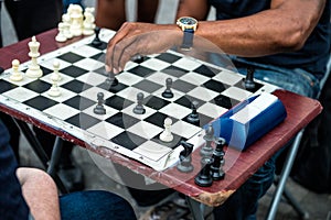 Close up of hands of people playing quick chess on the street with timer