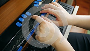 Close-up hands of person with blindness disability using computer with braille display or braille terminal a technology assistive