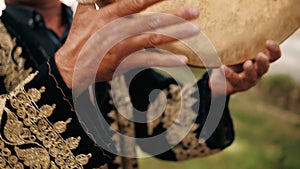Close up of hands playing tambourine or pandeiro musical instrument.