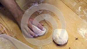 a close-up of hands preparing pizza dough