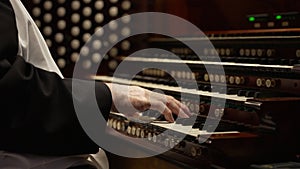 Close-up of the hands of a priest playing the church organ