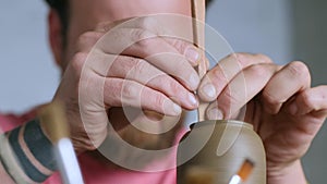 Close-up of the hands of a professional potter shaping a clay product on a potter`s wheel. Handmade. Small business. Crafting work