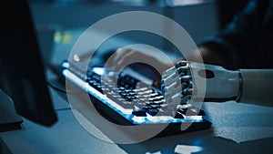 Close-up on Hands: Programmer With Disability Using Prosthetic Arm to Work on Computer Keyboard