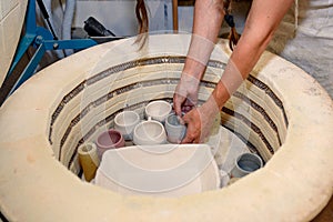 close up of hands putting raw clay in the kiln, oven for roasting unbaked clay handmade products, Unfinished ceramics and utensil