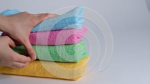 Close-up of hands putting stack of fresh bath towels on the bed sheet. Room service maid cleaning hotel room macro