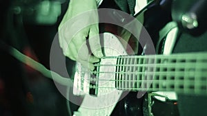 Close up of the hands of a rock guitarist and a bass guitar. Young professional bass player playing guitar solo. The