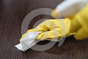 Close up of hands in rubber protective yellow gloves cleaning the white surface with a rag. Home  housekeeping concept