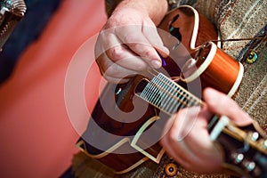 Close up hands senior man playing mandolin