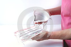 Close-up Hands of a senior woman holding a respirator and a medical protective mask.