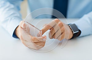 Close up of hands with smart phone and watch