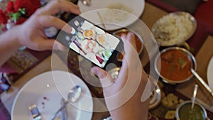 Close up of hands with smartphone taking a pic of indian food for social network site. 3840x2160