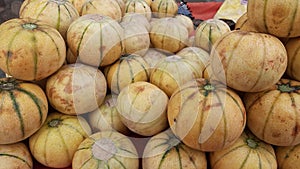 Close up of hands sorting through cantaloupes at a stand in an outdoor in India, Muskmelons in a supermarket