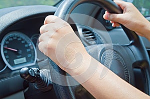 close-up of hands on a steering wheel