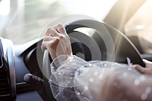 Close-up of hands on steering wheel while driving a car