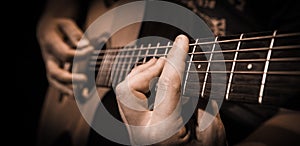 Close up hands on the strings of a guitar