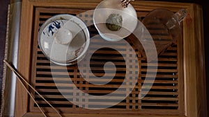 Close up hands of tea lover taking green tea cup from wooden table top view