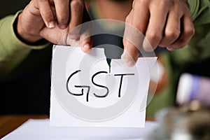 Close up of Hands tearing of GST paper - concept against goods and service tax.