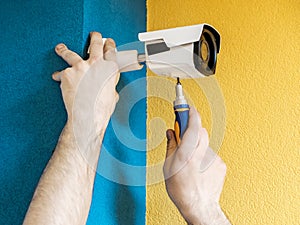 Close-up hands of technician adjusting CCTV camera