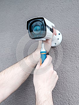 Close-up hands of technician adjusting CCTV camera