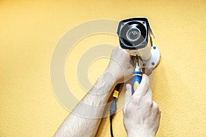 Close-up hands of technician adjusting CCTV camera