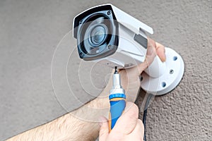 Close-up hands of technician adjusting CCTV camera