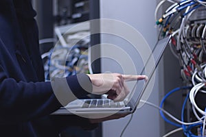 Close up of hands technician working on laptop in data center photo