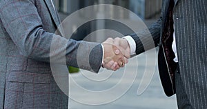Close up of the hands of top managers in business suits, shake hands with each other, at Business center background