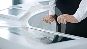 Close-up of hands touching modern screen in the hi-tech office or software lab