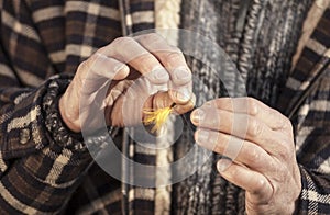 Close up of hands tying fishing fly