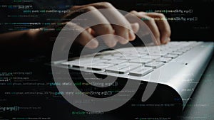 Close-up of Hands Typing on a Computer Keyboard with Programming Code in the Background Representing Software