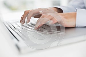 Close up of hands typing on laptop keyboard