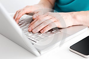 Close-up of hands typing on laptop keyboard